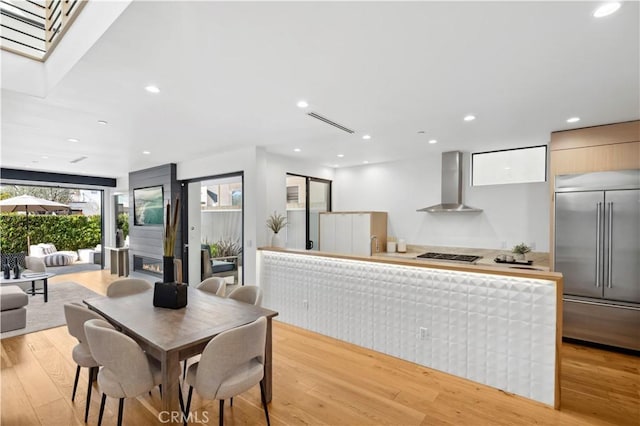 dining area featuring light wood-type flooring and a fireplace