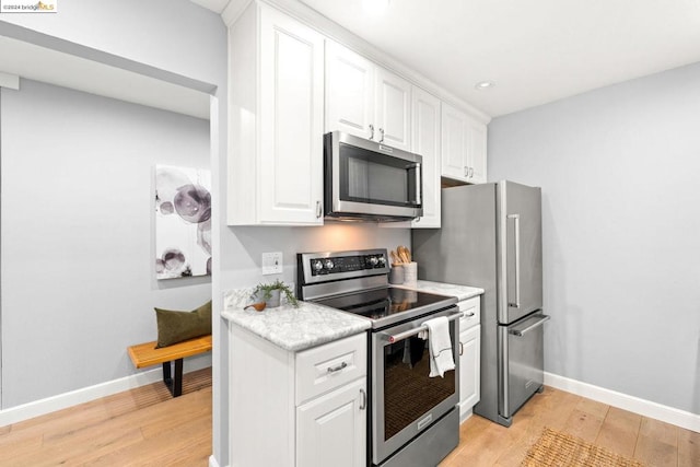 kitchen featuring white cabinets, light hardwood / wood-style flooring, and stainless steel appliances