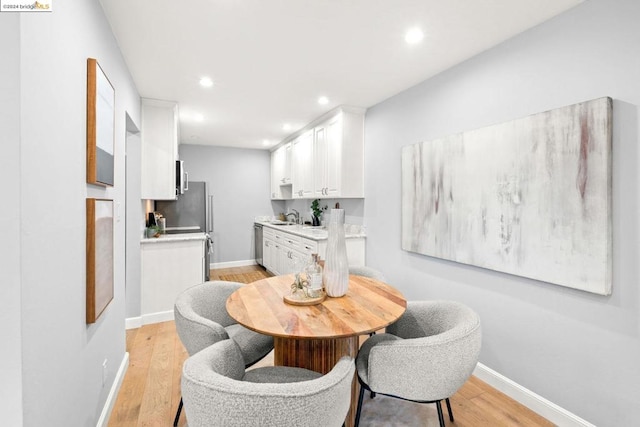 dining room with light hardwood / wood-style floors and sink