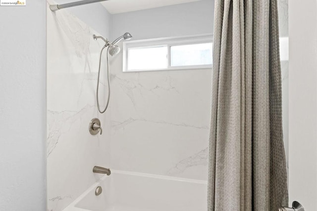 bathroom with shower / bath combo with shower curtain