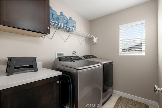 laundry area with cabinets, independent washer and dryer, and light tile patterned floors