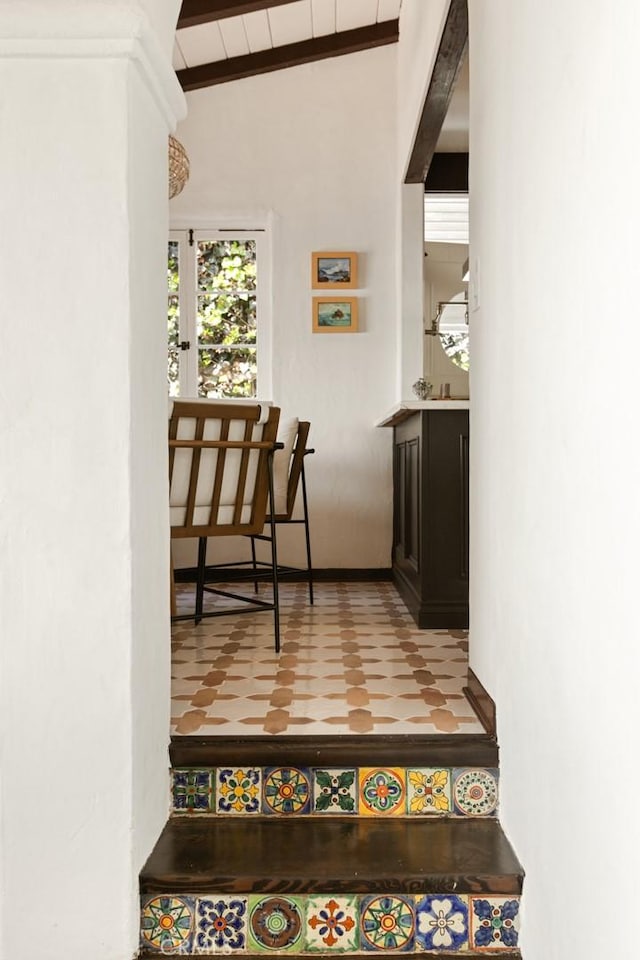 corridor with tile patterned flooring and vaulted ceiling with beams