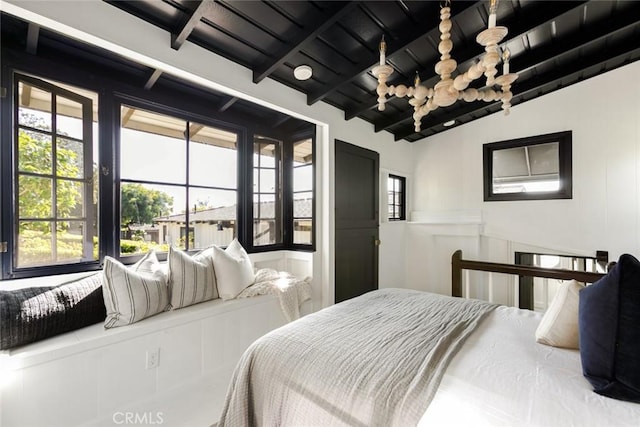 bedroom with multiple windows and lofted ceiling with beams