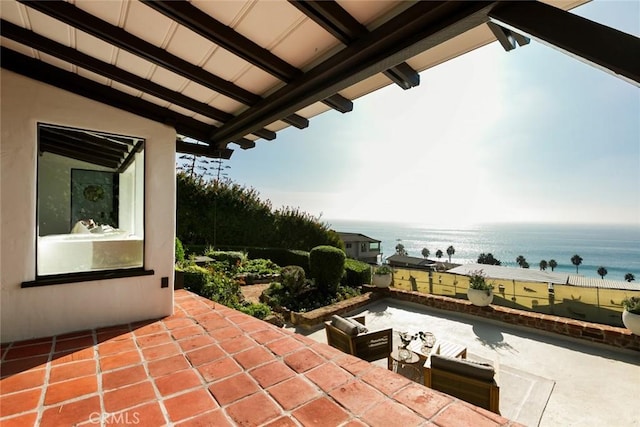 view of patio featuring a water view and a beach view