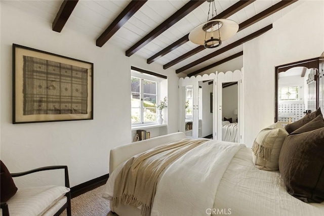 bedroom featuring vaulted ceiling with beams