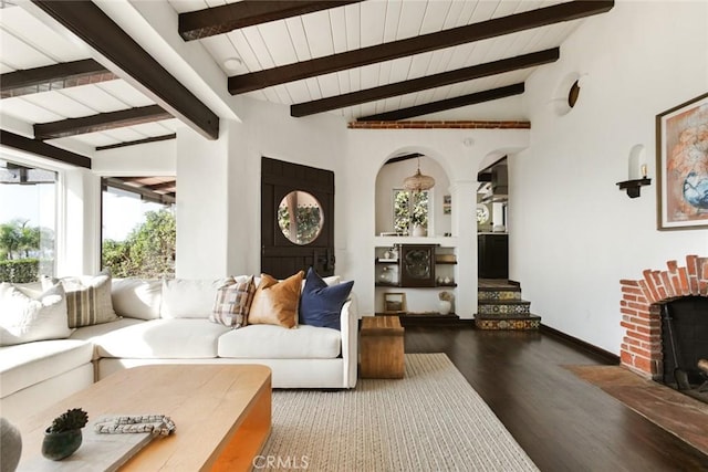 living room featuring a fireplace, wood-type flooring, and vaulted ceiling with beams