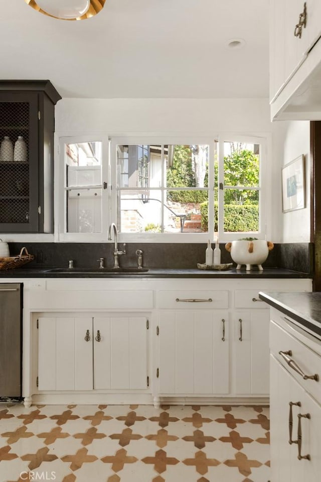 kitchen featuring dishwasher, white cabinetry, and sink