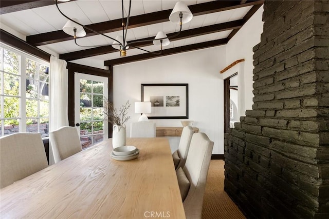 dining room featuring carpet flooring and vaulted ceiling with beams