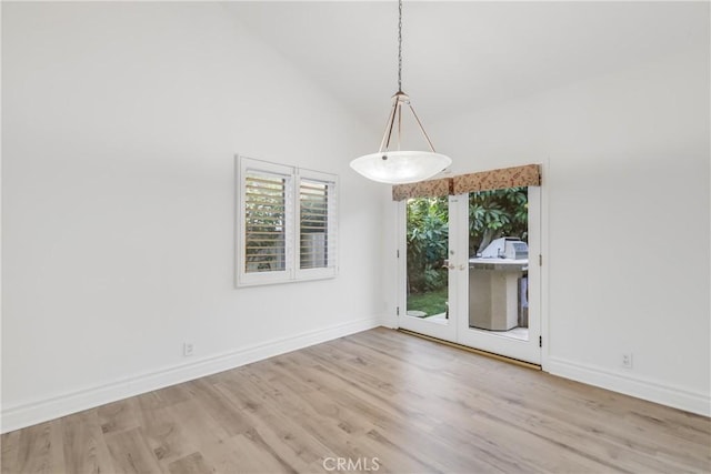 unfurnished dining area with light hardwood / wood-style flooring and high vaulted ceiling