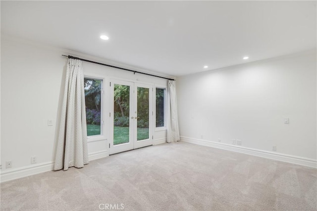 unfurnished room featuring light colored carpet and french doors