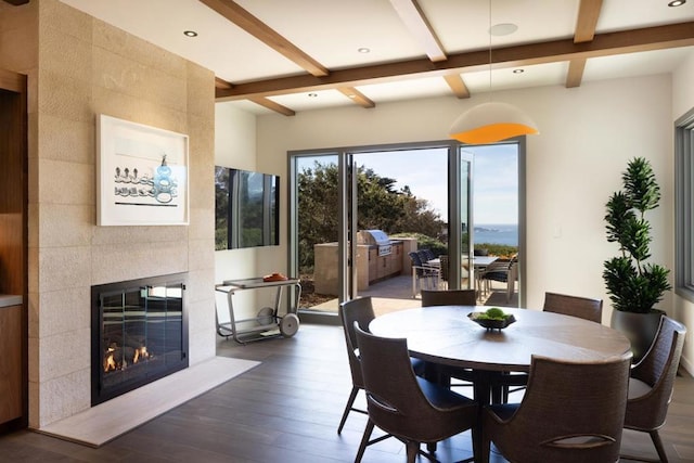 dining space with dark hardwood / wood-style flooring, a fireplace, beamed ceiling, and coffered ceiling