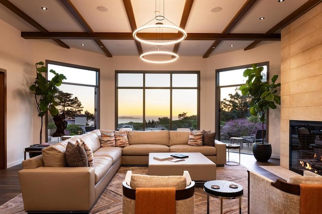 living room featuring a tiled fireplace, beamed ceiling, wood-type flooring, and coffered ceiling