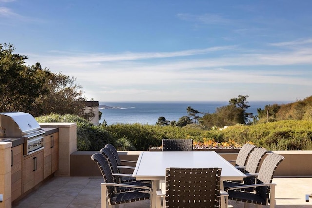 view of patio featuring area for grilling, a water view, and grilling area