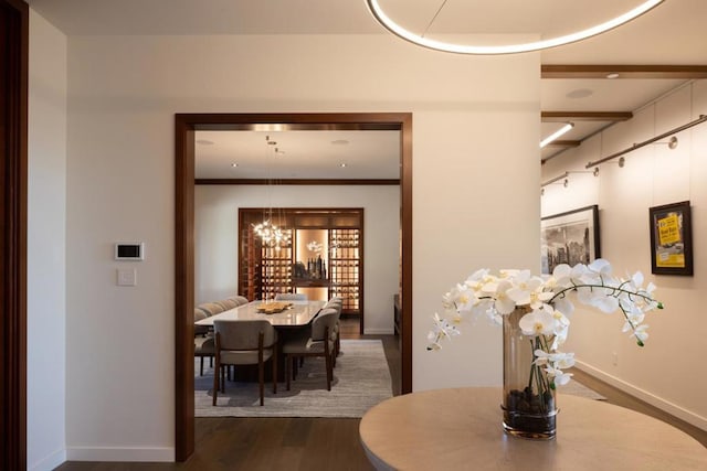 dining space with dark hardwood / wood-style floors and an inviting chandelier