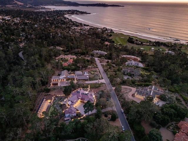 aerial view at dusk featuring a water view