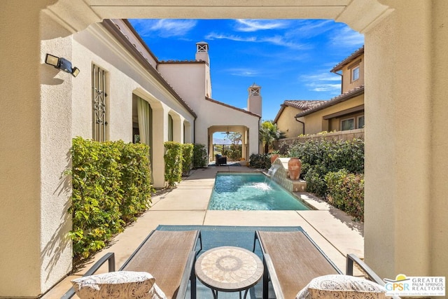 view of pool featuring pool water feature and a patio area