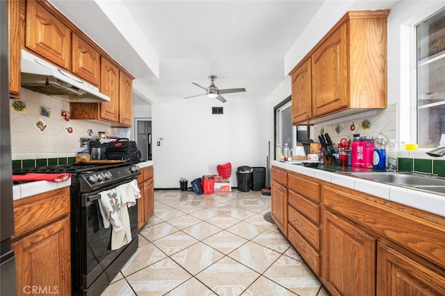 kitchen featuring backsplash, high end black range, ceiling fan, light tile patterned floors, and tile counters