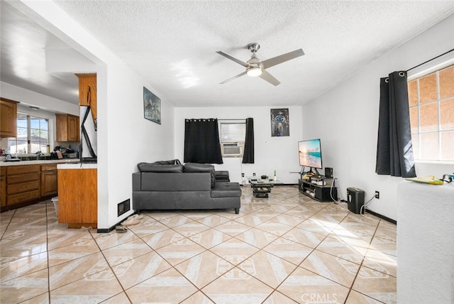 living room featuring a textured ceiling, ceiling fan, and cooling unit