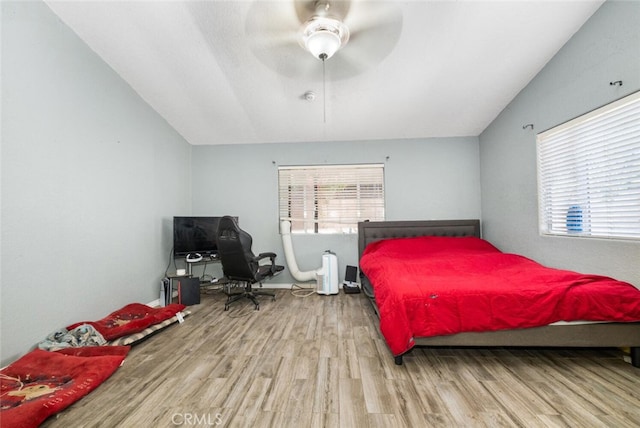 bedroom with wood-type flooring, vaulted ceiling, and ceiling fan