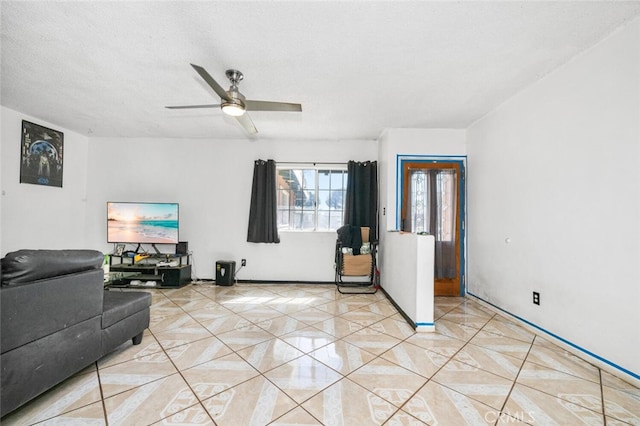 living room with ceiling fan and a textured ceiling