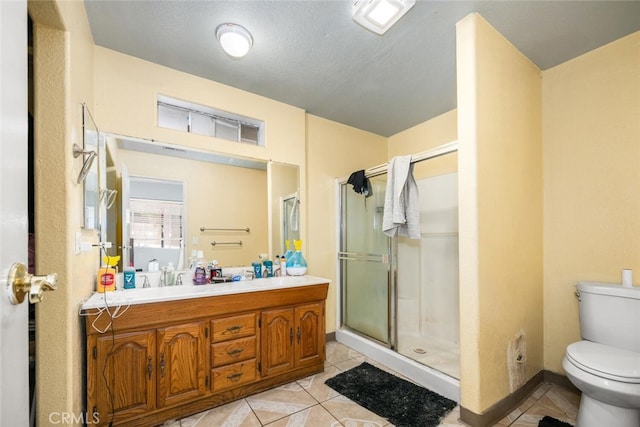 bathroom with walk in shower, tile patterned flooring, a textured ceiling, toilet, and vanity