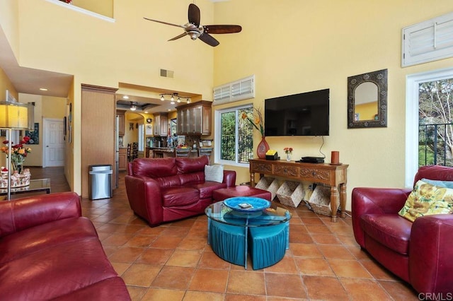 tiled living room with a high ceiling, plenty of natural light, and ceiling fan