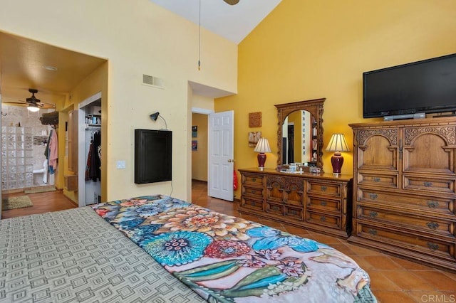 bedroom featuring connected bathroom, a spacious closet, a high ceiling, tile patterned flooring, and a closet