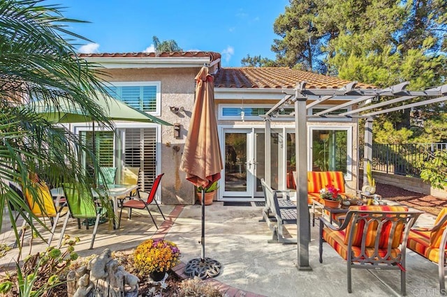 rear view of house with french doors, a patio, and a pergola