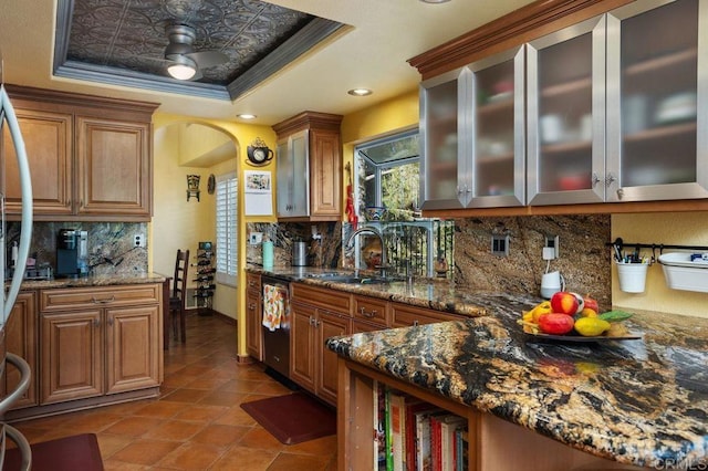 kitchen with dishwasher, crown molding, sink, decorative backsplash, and a tray ceiling