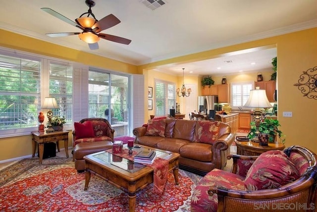 living room with ornamental molding and ceiling fan with notable chandelier