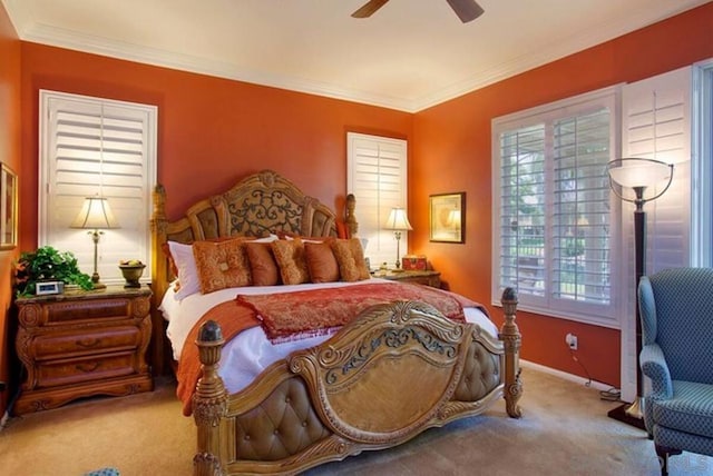 carpeted bedroom featuring ceiling fan and crown molding