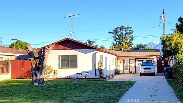 view of front of house with stucco siding, a front lawn, fence, concrete driveway, and an attached garage