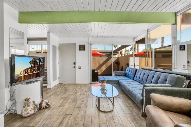 living room with light hardwood / wood-style flooring, beamed ceiling, and wooden ceiling