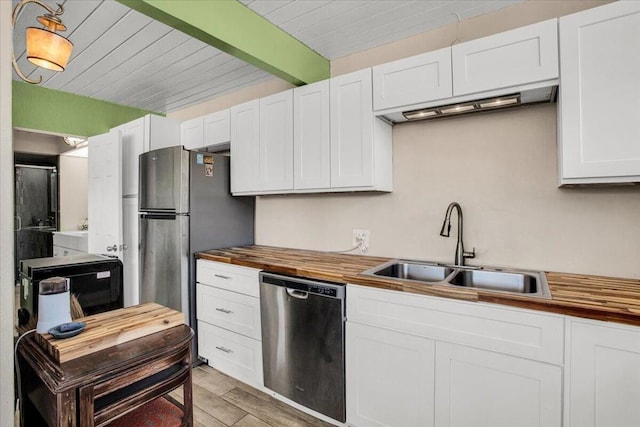 kitchen featuring wood counters, sink, light wood-type flooring, appliances with stainless steel finishes, and white cabinetry