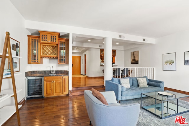 living room featuring dark wood-type flooring, wet bar, and beverage cooler