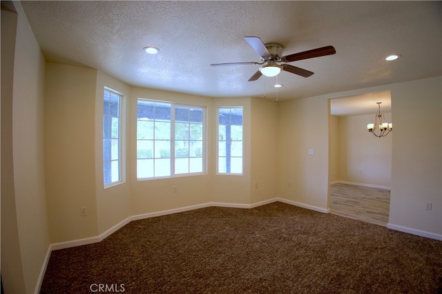 spare room featuring a textured ceiling, carpet flooring, and ceiling fan with notable chandelier