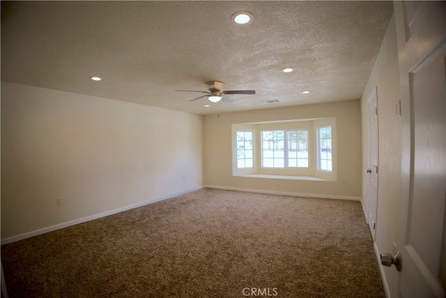 carpeted spare room with a textured ceiling and ceiling fan