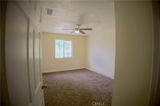 carpeted spare room with a textured ceiling and ceiling fan