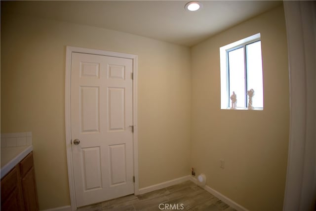 laundry area with cabinets and light hardwood / wood-style flooring