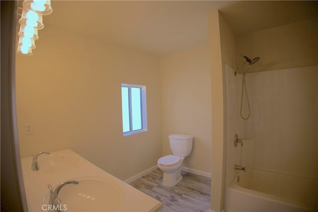 full bathroom featuring toilet, tiled shower / bath combo, hardwood / wood-style flooring, and sink