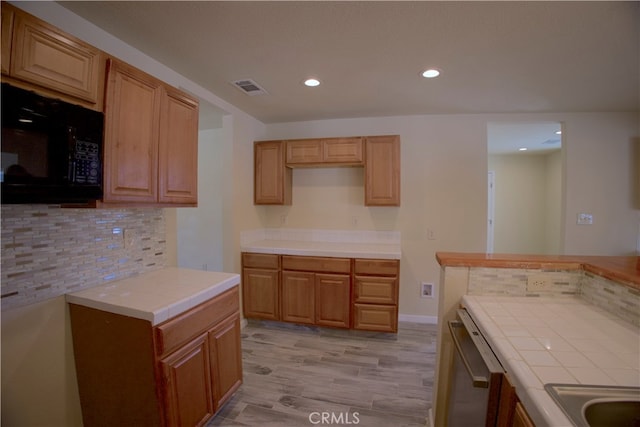 kitchen with backsplash, dishwasher, tile countertops, and light hardwood / wood-style floors