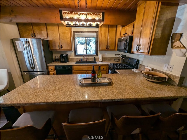 kitchen with black appliances, sink, wood ceiling, hanging light fixtures, and a breakfast bar