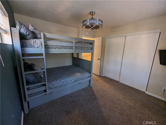 unfurnished bedroom with a closet and dark colored carpet