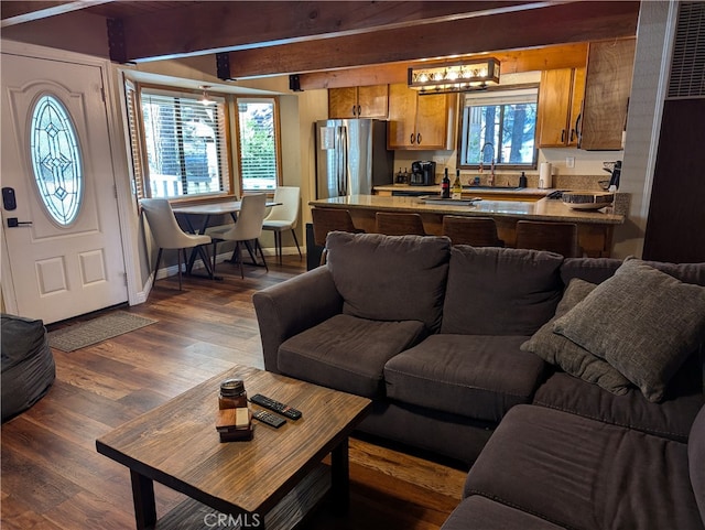 living room with beam ceiling, sink, and dark hardwood / wood-style floors