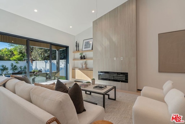 living room featuring a large fireplace, radiator, and lofted ceiling