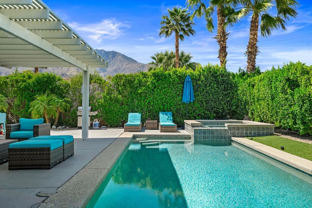 view of swimming pool featuring a patio, a mountain view, and an in ground hot tub