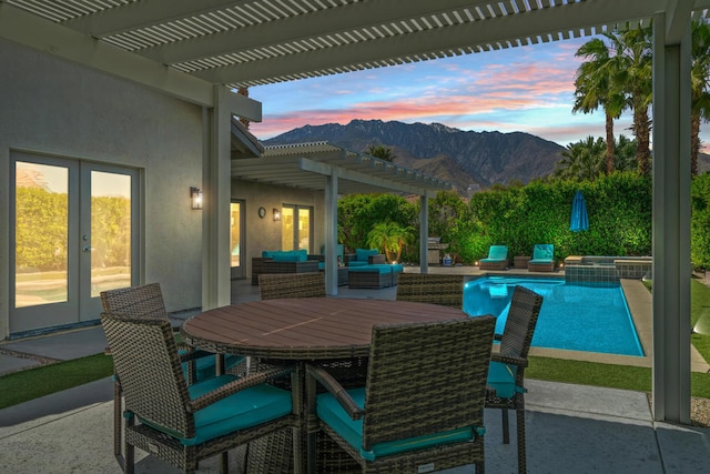 patio terrace at dusk with a pergola, a mountain view, and outdoor lounge area