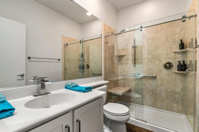 bathroom with a shower with door, vanity, toilet, and tile patterned floors