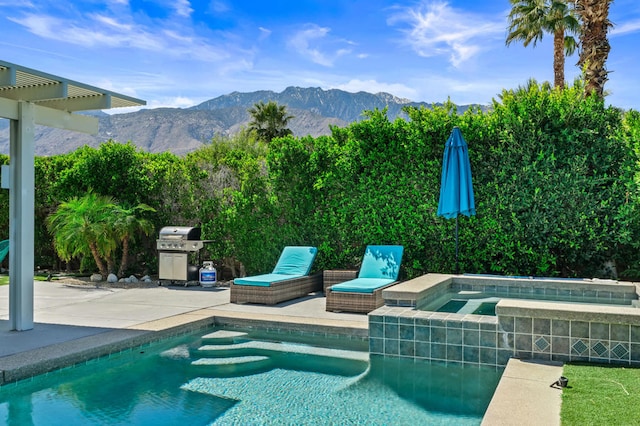 view of swimming pool with a patio area, a mountain view, an in ground hot tub, and a grill