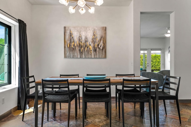 dining room with ceiling fan with notable chandelier